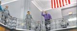 Tedmond Grady of AFLCMC sets his paper airplane in flight as other participants look on in the balcony of Bldg. 12’s rotunda.