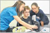 Natalie Livingston assists Megan George, an 8th grader from Baker Middle School (Fairborn), and Jessica Meyer, an 8th grader from Ankeney Middle School (Beavercreek), as they examine DNA sampling with a microscope (Air Force photos by Diane Kofoed)